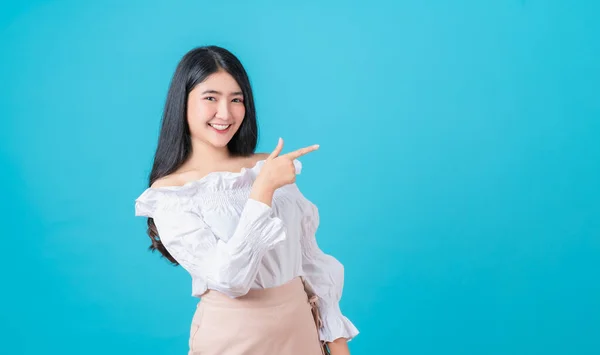 Sonriente Mujer Asiática Pie Señalando Dedo Sobre Fondo Azul —  Fotos de Stock