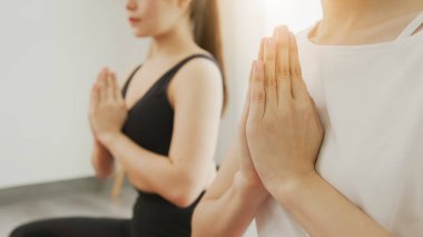 Yakın çekimde, evdeki oturma odasında yoga yapan bir grup genç Asyalı kadın vuruldu..