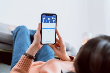 Bangkok, Tayland - 30 Ağustos 2020: Kadın eli Apple iphone 11 'de Facebook ekranına basıyor, Sosyal medya bilgi paylaşımı ve ağ paylaşımı için kullanıyor.