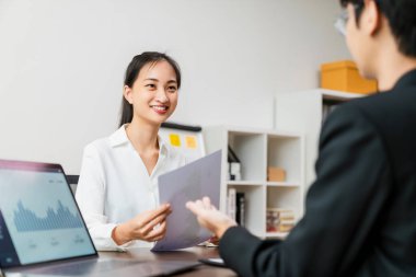 Çekici Asyalı iş kadını toplantısı ve ofiste dizüstü bilgisayarlı bir masada takım çalışması planlaması hakkında beyin fırtınası..