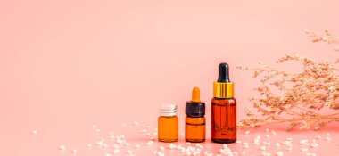 İlaç şişesi yerleştirilmiş. Pembe arka plan için boş etiket paketi. Doğal güzellik ürünleri kavramı.