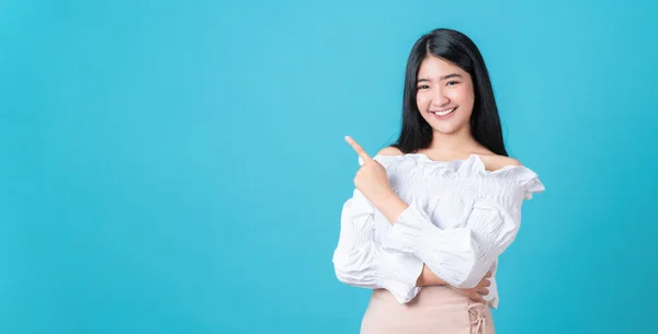 Sonriente Mujer Asiática Pie Señalando Dedo Sobre Fondo Azul —  Fotos de Stock