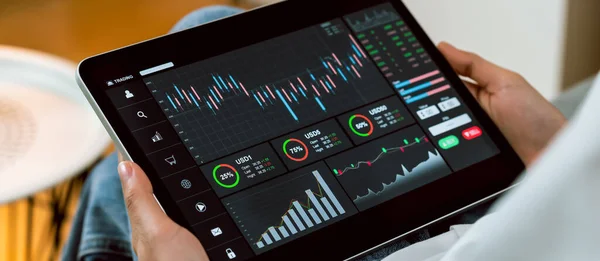 证券交易市场的概念 手工交易者触摸数字平板电脑时 桌上放着分析蜡烛线的图表 屏幕上放着图表 图库图片