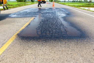 Yol onarım. İnşaat işçisi asfaltlama.