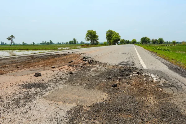 Asfalt karayolu üzerinde büyük çukur.