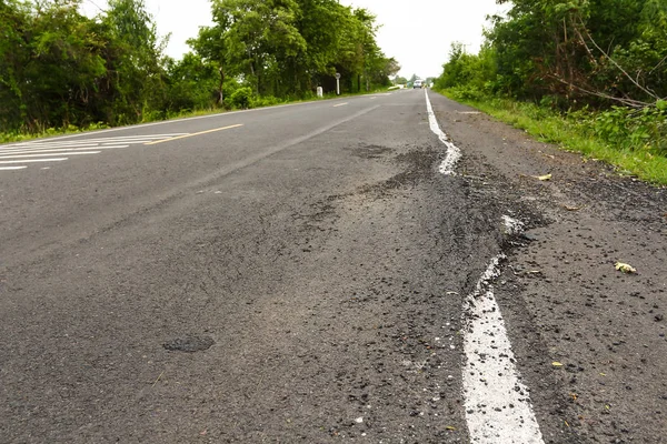 Asfalt karayolu üzerinde büyük çukur.