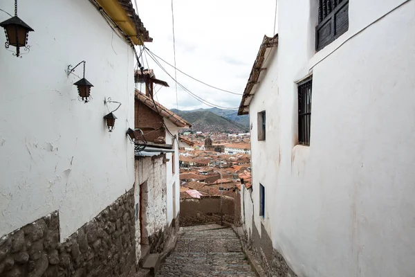 Cusco, Peru. Şehre dar bir sokak iniyor. Çatıların ve merkez meydanın görünümü 