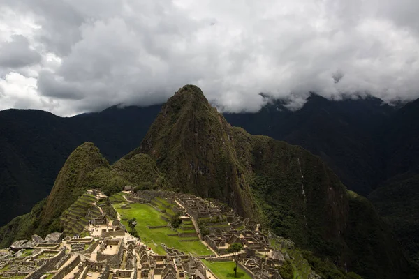 Machu Picchu şehir bulutlar aracılığıyla güneş tarafından aydınlatılır. İnkalar şehri. Dünyanın Yeni Yedi Harikasından Biri