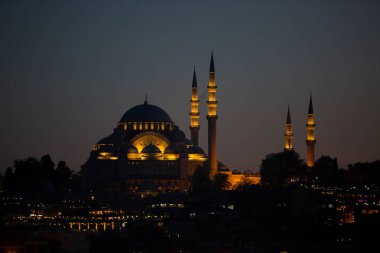 Türkiye, Istanbul-3 Mayıs 2019: Süleymaniye Camii şafak vakti sarı renkte vurgulanır. Işıklı minareli cami gece görünümü
