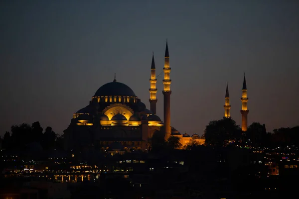 Türkiye, Istanbul-3 Mayıs 2019: Süleymaniye Camii şafak vakti sarı renkte vurgulanır. Işıklı minareli cami gece görünümü