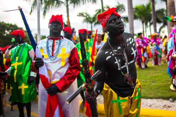 Dominik Cumhuriyeti, Punta Cana - 3 Mart 2018: Karnaval'da renkli temalı kostümlü insanlar. Ulusal renklerle boyanmış yüzler. Bir festivalde vudu şamanları gibi giyinmiş iki siyah adam