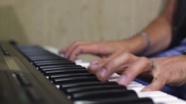 Synthesizer'ı oynuyorum. Müzisyen adam elektrikli piyano çalıyor. eller yakın çekim