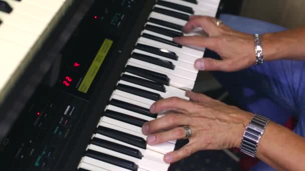 男がシンセサイザーを弾く エレクトリックピアノを弾くミュージシャンがクローズアップ 上からの眺め — ストック動画