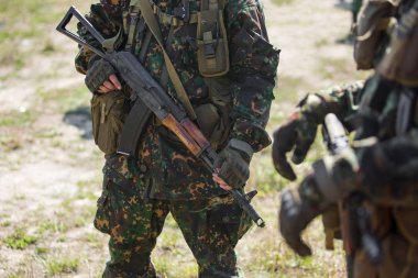Yeşil kamuflajlı iki askerin yakın çekim. Askerler Ellerinde Ak47 saldırı tüfekleri tutun. Savunma birimi