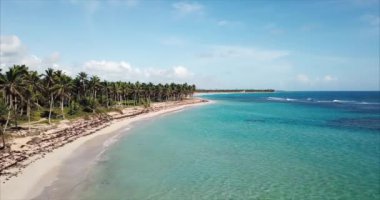 Vahşi bir sahil boyunca hareket halindeki hava manzarası. Turkuaz su ve bir cennet adasında beyaz kum. Açık mavi gökyüzü, Atlantik Okyanusu 'nun güzelliği ve sükuneti. Punta Cana, Dominik Cumhuriyeti