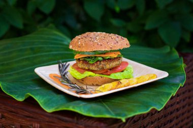 Kızarmış taze muz, taze sebze ve tam buğday ekmekli sebzeli burger büyük yeşil bir yaprağın üzerinde servis edilir. Vejetaryen fast food geçmişi