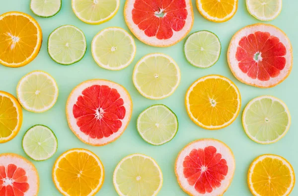 Citrus pattern on green background. Assorted citrus fruits. Slices of orange, tangerine, lemon, lime. Top view. Summer. Cocktail