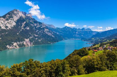 Walensee (Walen) gölünün panorama manzarası ve yürüyüş parkurundaki Alpler, gölün güney tarafındaki Glarus Kantonu, İsviçre.