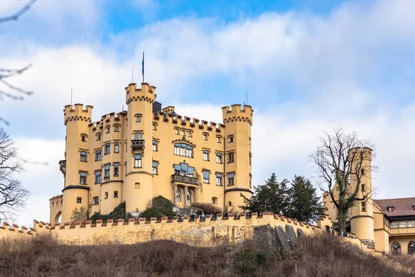 Meşhur Hohenschwangau Kalesi 'nin güzel manzarası. Kışın güneşli bir günde, mavi gökyüzü ve bulut arkaplanı, Schwangau, Bavyera, Almanya