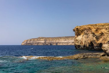 Dwejra Körfezi kıyısında göz kamaştırıcı bir manzara. Gök Pencere harabeleri ve Malta 'daki Gozo adasındaki güzel deniz suyu.