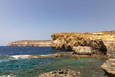 Dwejra Körfezi kıyısındaki panorama manzarası. Gök Pencere harabesi ve Malta 'daki Gozo adasındaki güzel deniz suyu.