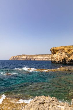 Dwejra Körfezi kıyısında göz kamaştırıcı bir manzara. Gök Pencere harabeleri ve Malta 'daki Gozo adasındaki güzel deniz suyu.