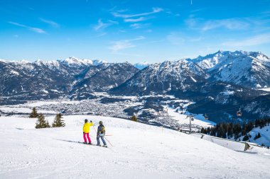 Avusturya 'nın küçük bir kasabası olan Reutte' de kar manzaralı Panorama 'da, kayak yamacı ve kayak yapan insanlar ön planda, Tyrol, Avusturya