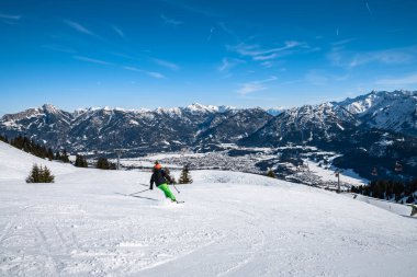 Avusturya 'nın küçük bir kasabası olan Reutte' de kar manzaralı Panorama 'da, kayak pisti ve insanlar ön planda kayak yapıyor, Tyrol, Avusturya