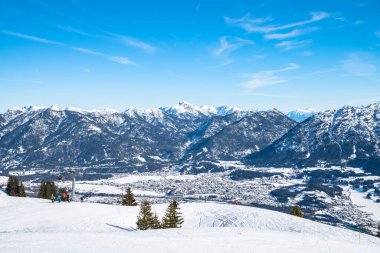 Kış mevsiminde Avusturya Alplerini kaplayan kar manzaralı Reutte teleferik istasyonunun tepesinde, ön planda kayak artıklarıyla, Tyrol, Avusturya