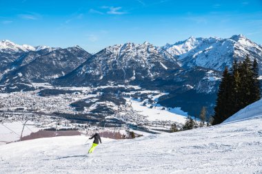 Avusturya 'nın küçük bir kasabası olan Reutte' de kar manzaralı Panorama 'da, kayak yamacı ve kayak yapan insanlar ön planda, Tyrol, Avusturya
