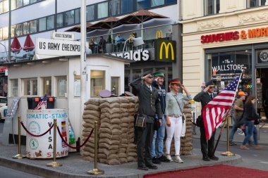 Berlin, Almanya - 19 Nisan 2019 - Almanya 'daki Charlie Kontrol Noktası' nda Soğuk Savaş sırasında eski Amerikan askeri üniformalı adamlarla hatıra fotoğrafı çeken turistler.