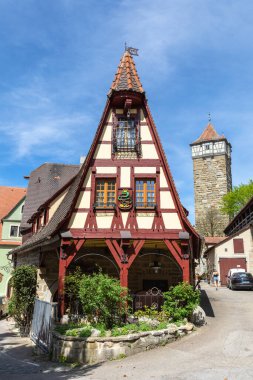 Ortaçağ Rothenburg ob der Taube kasabasındaki tarihi Gerlach Demirci Dükkanı ve Roeder Kapı Kulesi 'nin güzel manzarası güneşli bir günde, Bavyera, Almanya