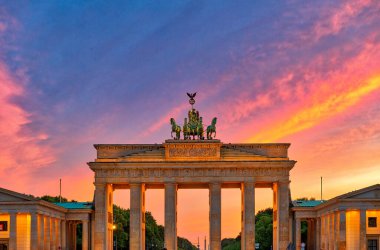 Berlin 'deki Brandenburg Kapısı' nın alacakaranlıktaki göz kamaştırıcı manzarası, arka planda renkli alacakaranlık, Berlin, Almanya