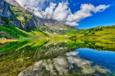 Güneşli bir yaz gününde İsviçre 'nin Glarus Kantonu Braunwald' daki Oberlegisee Gölü 'nün göz kamaştırıcı manzarası.