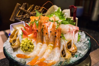 Tipik Japon yemeği Sashimi 'nin yakın görüntüsü. Çok taze çiğ et, balık ve ince dilimlenmiş deniz ürünlerinden oluşan bir Japon lezzeti..