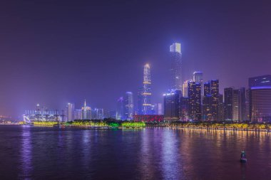 Guangzhou 'nun merkezi iş alanının göz kamaştırıcı manzarası Zhujiang Nehri' nin nehir kıyısında aydınlık gökdelenler ve Çin 'in Guangdong Eyaleti' nin sularındaki yansımalarıyla.