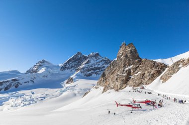 Jungfraujoch, İsviçre - 28 Aralık 2015 Jungfrau ve Sphinx Gözlemevi manzaralı Jungfraujoch tren istasyonunun dışındaki kış yürüyüşü geçidinde turistler.