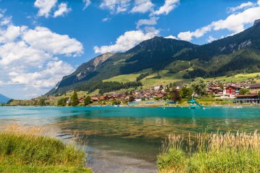 İsviçre 'nin Bernese Oberland bölgesindeki Lungernsee' nin göl kıyısındaki küçük Lungern kasabasının göz kamaştırıcı manzarası. Bu kasaba Lucerne ve Interlaken arasındaki demiryolu hattında yer alıyor..
