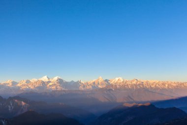 Dağ sırasının panorama manzarası, Çin 'in Sichuan Eyaleti' nde sabah güneşinde sığırların tepesinden Minya Konka (756 metre) de dahil olmak üzere.