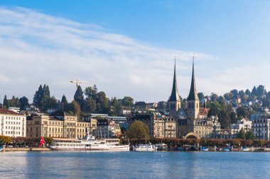 Göl kenarındaki Lucerne manzarası, ünlü St. Leodegar kilisesi, güneşli bir yaz gününde İsviçre 'de bulutlar ve mavi gökyüzü.