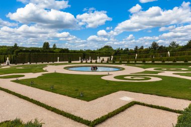 Güneşli bir günde Versailles Sarayı 'ndan sonra bahçenin bir köşesinin manzarası bulutlar ve mavi gökyüzü, Paris, Fransa