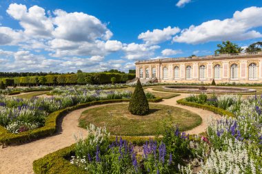 Güneşli bir günde, Grand Trianon Sarayı 'nın bahçesinin bir köşesinde bulutlar ve mavi gökyüzü. Versailles, Paris, Fransa 'nın kuzeybatısında ünlü bir saray.