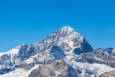 Güneşli bir sonbahar gününde Gornergrat, Zermatt, Valais, İsviçre 'den gelen kar ve mavi gökyüzü bulutuyla Weisshorn' un İsviçre Alpleri 'nin zirvesini yakından görmek hayret verici.