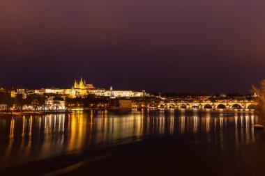 Prag Kalesi ve St. Vitus Katedrali ile Vltava Nehri üzerindeki Charles Köprüsü ve Çek Cumhuriyeti 'nin eski Prag kentinin merkezindeki panorama gece görüşü aydınlandı.