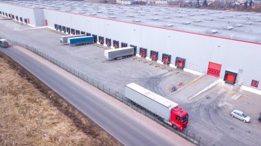 Endüstri binasının önüne park etmiş kamyonların hava görüntüsü. Havadan