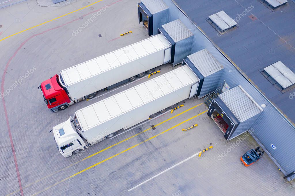 Aerial Top View of White Semi Truck with Cargo Trailer Parking with Other Vehicles on Special Parking Lot