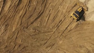 Bir şantiyede çalışan bir buldozerin havadan videosu. Drone