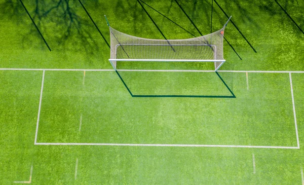 Red de fútbol en el fondo de un campo de fútbol verde. Antena — Foto de Stock