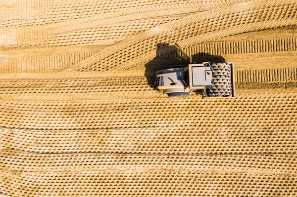 Flygfoto av en ång rulle och en traktorgrävare på en vägarbete — Stockfoto