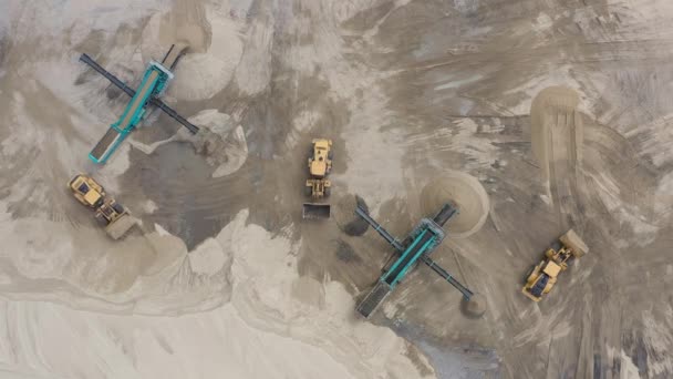 Top luchtfoto van bulldozer laad zand in lege dump truck in openlucht steengroeve. — Stockvideo